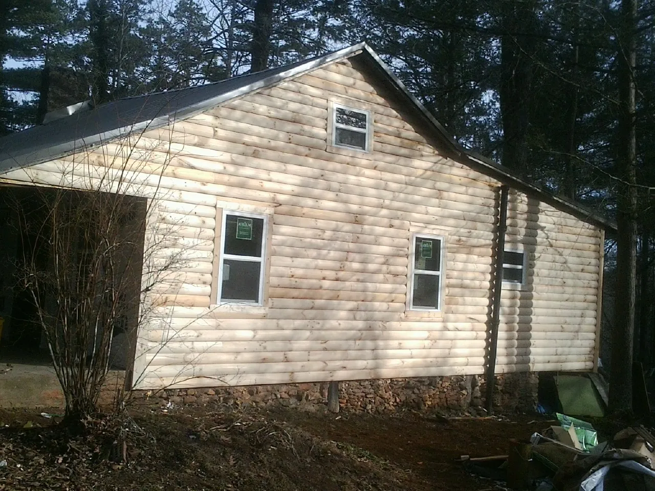 New log siding and dark metal roofing on a gable end in La Fayette